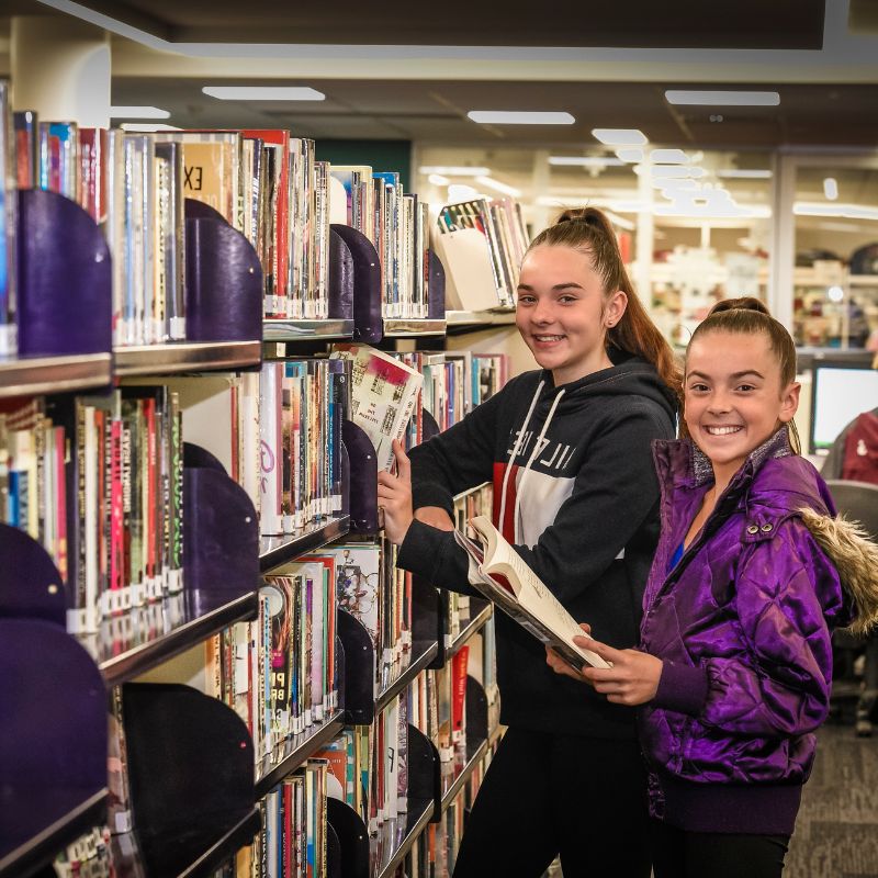 2 young people browsing books in library