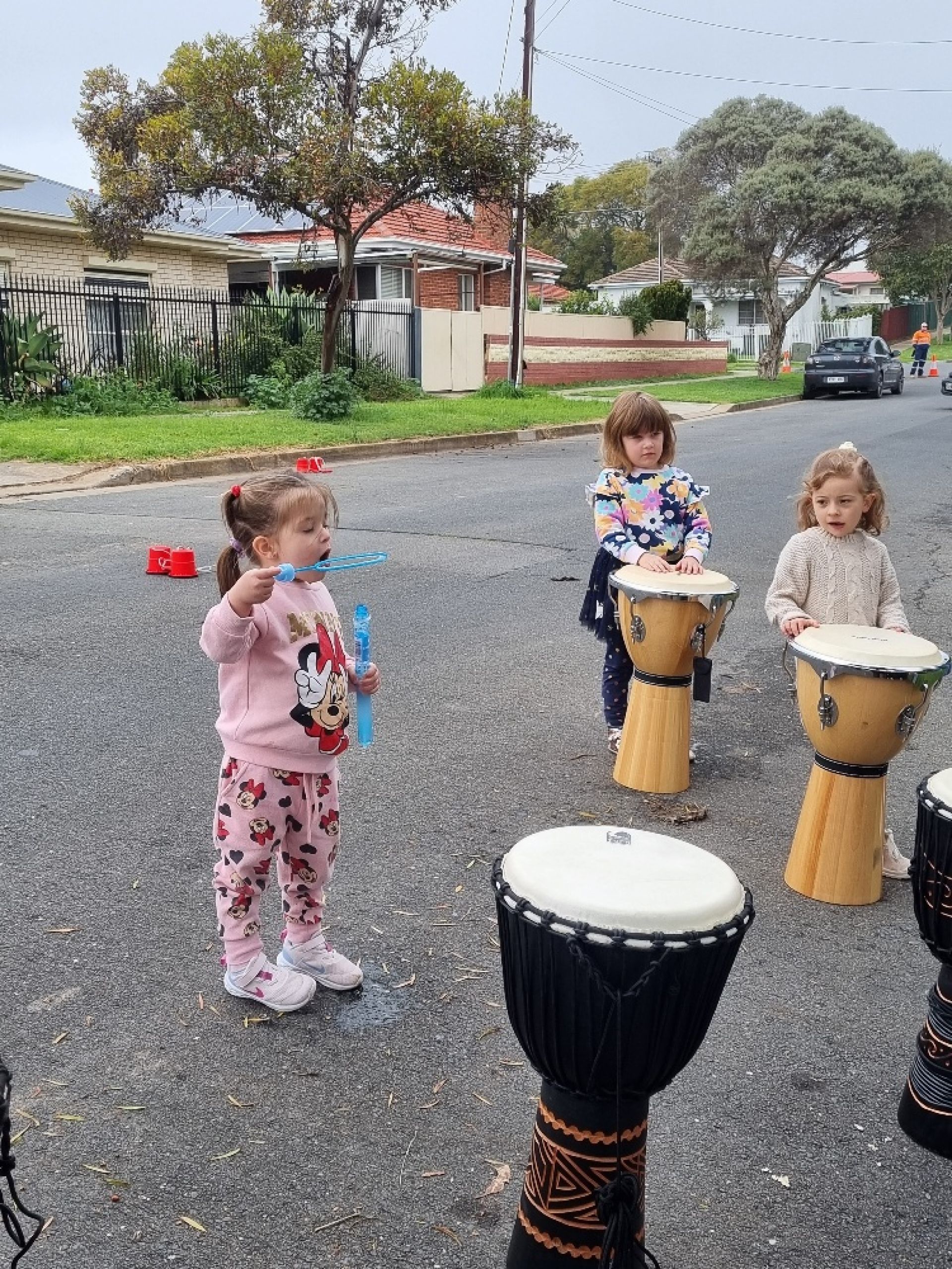 Children on the street playing drums and blowing bubbles