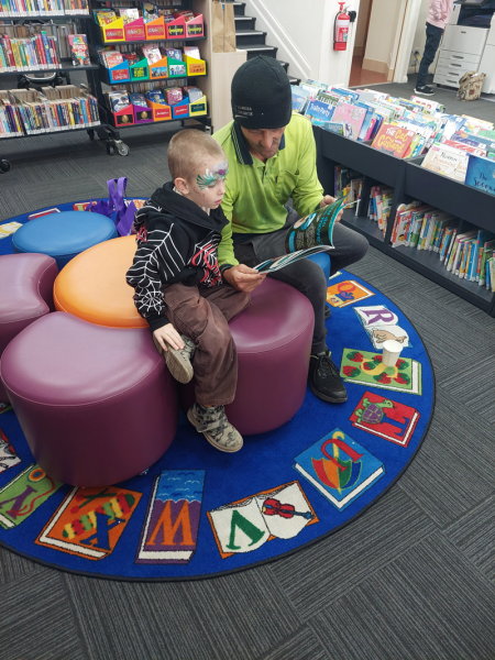 Playgroup - Carer reading with a child at the library