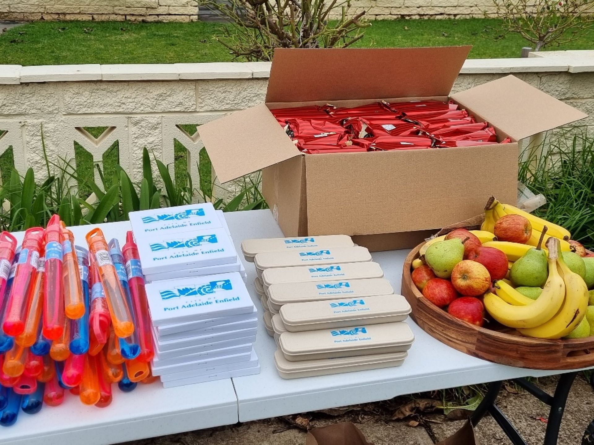 A table with fruit, bubbles and other giveaways