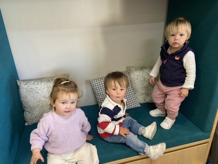 3 young children on a cushioned seat