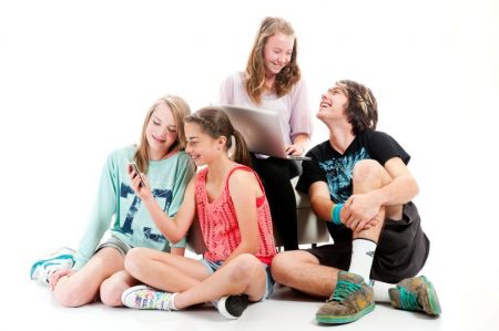 Group of 4 youths looking at devices
